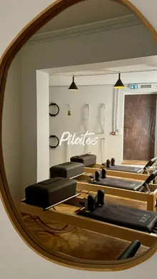 Reflet dans le miroir du studio, enseigne "Pilates"